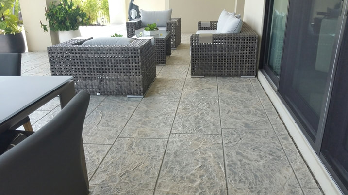Picture of the back patio of a house finished with a stamped concrete patio in a decorative pattern